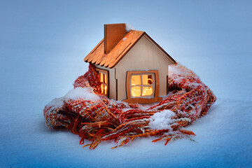 wooden house in the snow wrapped in a scarf, energy crisis, utility bills for gas and electricity ,...