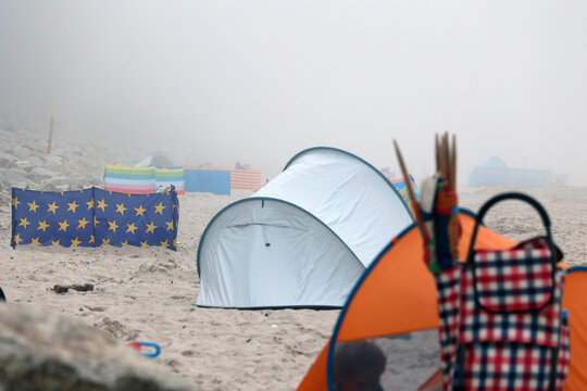 Mgła wisi nad plażą morza bałtyckiego. Słabo widać.