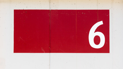A white number 6 on a red facade