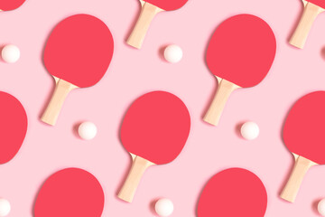 Repetitive pattern made of tennis racket and white ball on a pink pastel background. Creative layout.