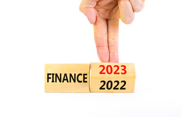 Planning 2023 finance new year symbol. Businessman turns a wooden cube and changes words Finance 2022 to Finance 2023. Beautiful white background, copy space. Business 2023 finance new year concept.