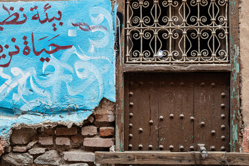 Old wooden door closed in a wall in Marrakesh Medina district, Morocco