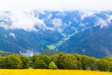 Mountain Landscape at Black Forest / View to valley village surrounded by forest mountains and sky clouds at top