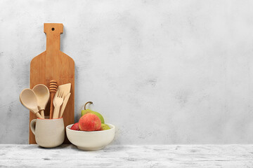 Empty rustic table with wooden cutlery, crockery and apple.Simple home kitchen interior, mockup for...