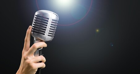 Classic black microphone with stage lighting background