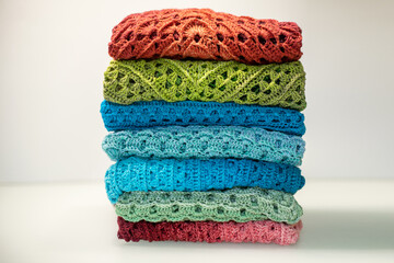 a stack of multi-colored knitted things on a white background