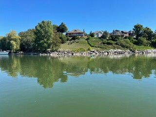 reflection of trees in the lake and house background