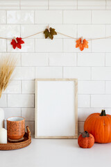 Living room interior design with autumn fall decor and picture frame mockup. Thanksgiving, Halloween holiday poster concept.
