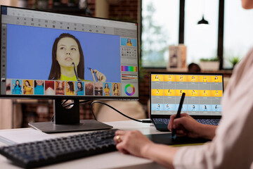 Creative freelancer editing picture with retouching software, using graphic tablet to edit image...