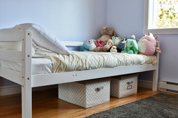 Modern child's room with favourite stuffies on bed and simple storage solution ideas for toys under...