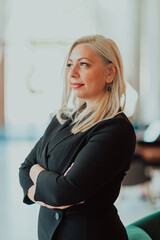 Portrait of business senior woman with crossed arms standing in modern corporation. Selective focus 