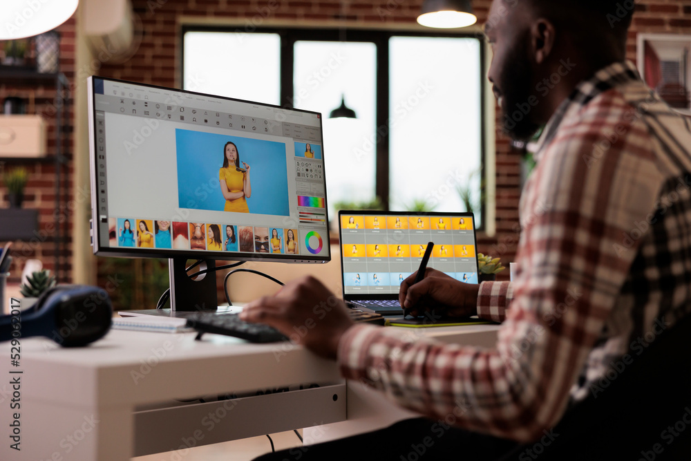 Poster content creator editing picture with retoucher software on computer, creating multimedia production 