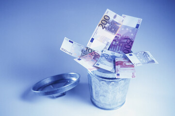 Euro banknotes in a wastepaper basket