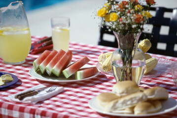 Watermelon slices and corn on the cob on a picnic table