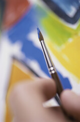 Close-up of a person holding a paintbrush