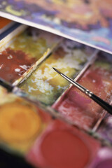 Close-up of a paintbrush on watercolors