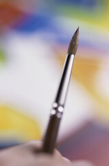Naklejka premium Close-up of a person's hand holding a paintbrush