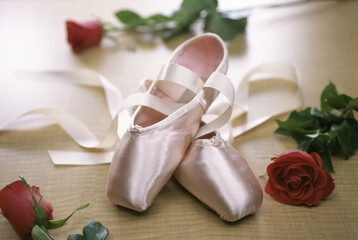 Obraz na płótnie Canvas Pair of ballet slippers with three roses