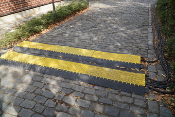 Yellow cable protection system laid on pavement at an event to avoid tripping hazards and ensure...