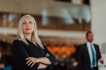 Portrait of business senior woman with crossed arms standing in modern corporation. Selective focus 
