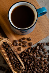 Blue cup of coffee with roasted coffee beans