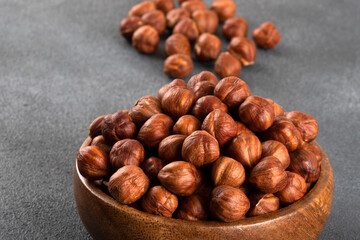 Top view of a bowl full of hazelnuts on dark background
