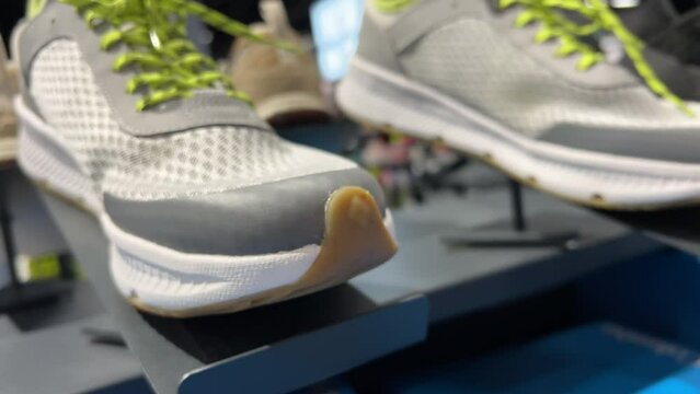 New running shoes are lined up on the shelf of a sports shoe store. Closeup