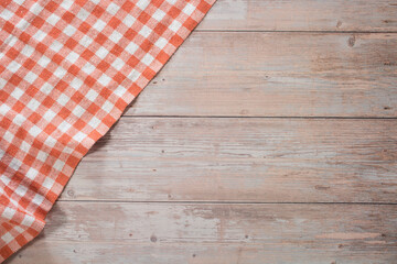 Orange and white checkered tablecloth on wooden table