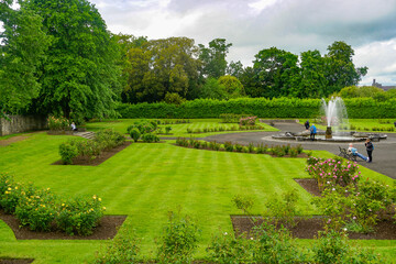 Kilkenny, Ireland: Tourists relaxing in the garden at Kilkenny Castle. The castle was built in 1195 to control a fording-point of the River Nore.
