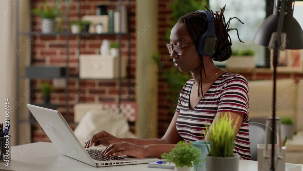 Poster startup employee listening to music and working from home, using laptop to do remote job on online n
