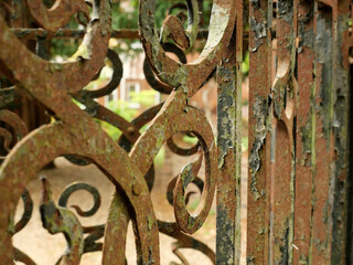weathered paint peeling off of rusted metal front gate railings