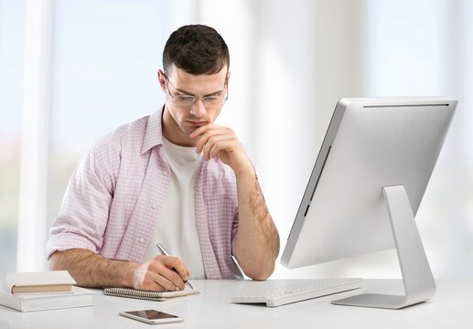 Concentrated Male Small Business Owner Looking At The Computer Screen While Sitting In Modern Office.