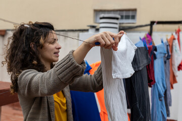 Latina woman hanging clothes on clothesline