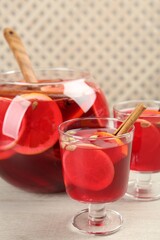 Glasses and bowl with aromatic punch drink on white wooden table