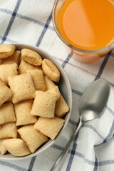 Bowl of sweet crispy corn pads and juice on kitchen towel, flat lay. Breakfast cereal