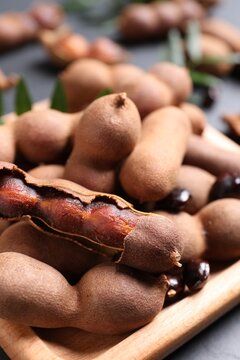 Wooden plate with delicious ripe tamarinds, closeup