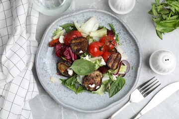 Delicious salad with roasted eggplant, basil and cheese served on grey marble table, flat lay