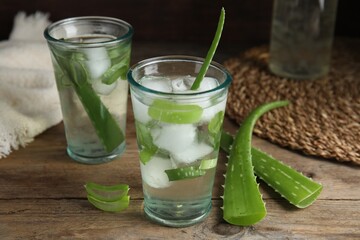 Fresh aloe drink with ice cubes on wooden table