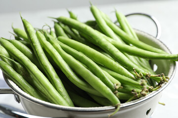 Fresh green beans in colander, closeup view