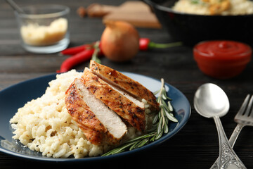 Delicious risotto with chicken on plate, closeup