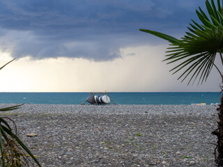 Folded windsurfing boards. End of beach season. Not bathing time. High wave.