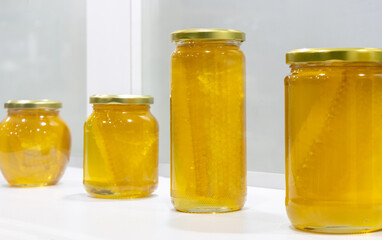 Honey in glass jars on the white background