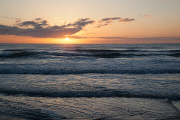 Obraz premium Sunset over the ocean waves