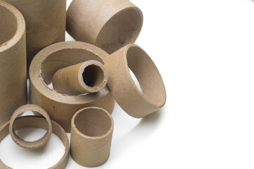 Cardboard cores of different sizes for winding various strips of material in the printing house. Industrial paper cores, tube and spools on a white background. Selective focus