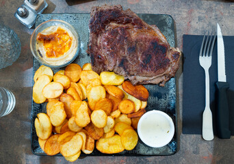 Spicy roasted veal entrecote with potato served with gratin with champignons and cheese sauce, typical french cuisine