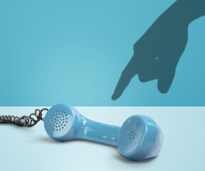 old phone with hand picking up handset, on background.