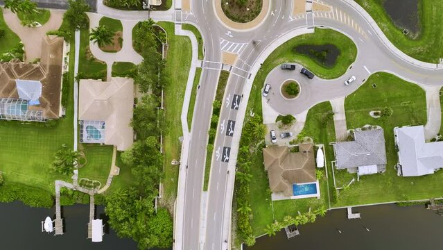 Aerial view of american suburban area with rural road roundabout intersection with moving cars traffic. Circular transportation crossroads in Florida