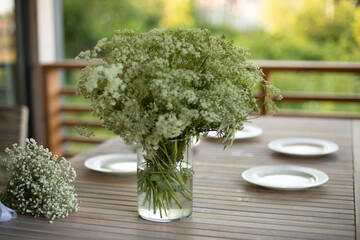 Vase on table. Dining table on veranda. Lunch in summer.
