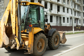 Yellow tractor, Construction machinery in city. Heavy vehicles with big wheels.