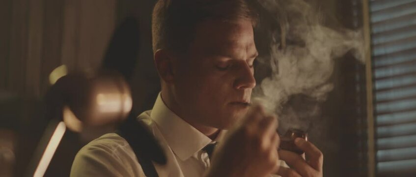 Evening in office. Man smoking pipe and thinking. Retro style detective using deduction for solving challenging cases.
